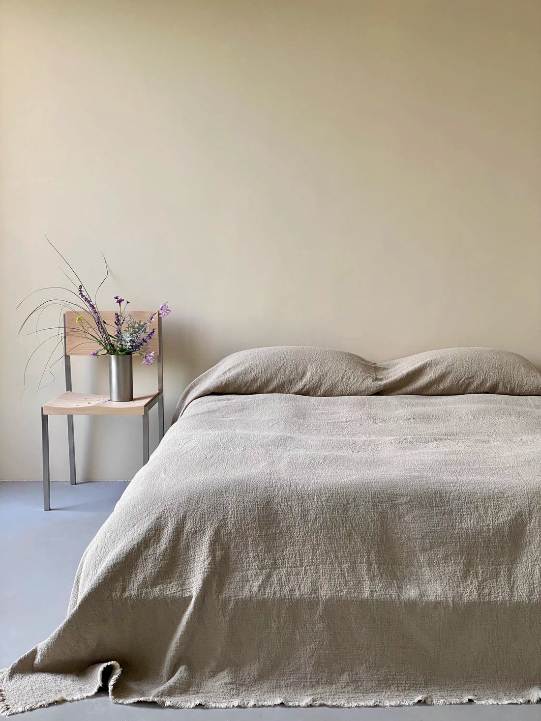 Stonewashed French flax linen duvet thin quilt in classic natural linen color draped across minimalist bed showing breathable linen texture