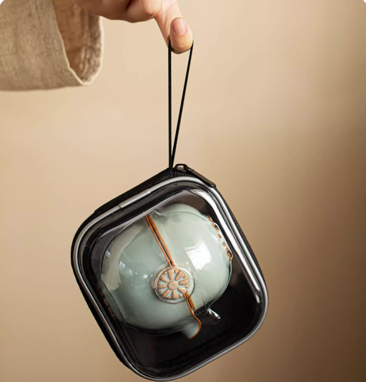 Sky blue Ru kiln ceramic tea set stored inside black travel case being held by hand
