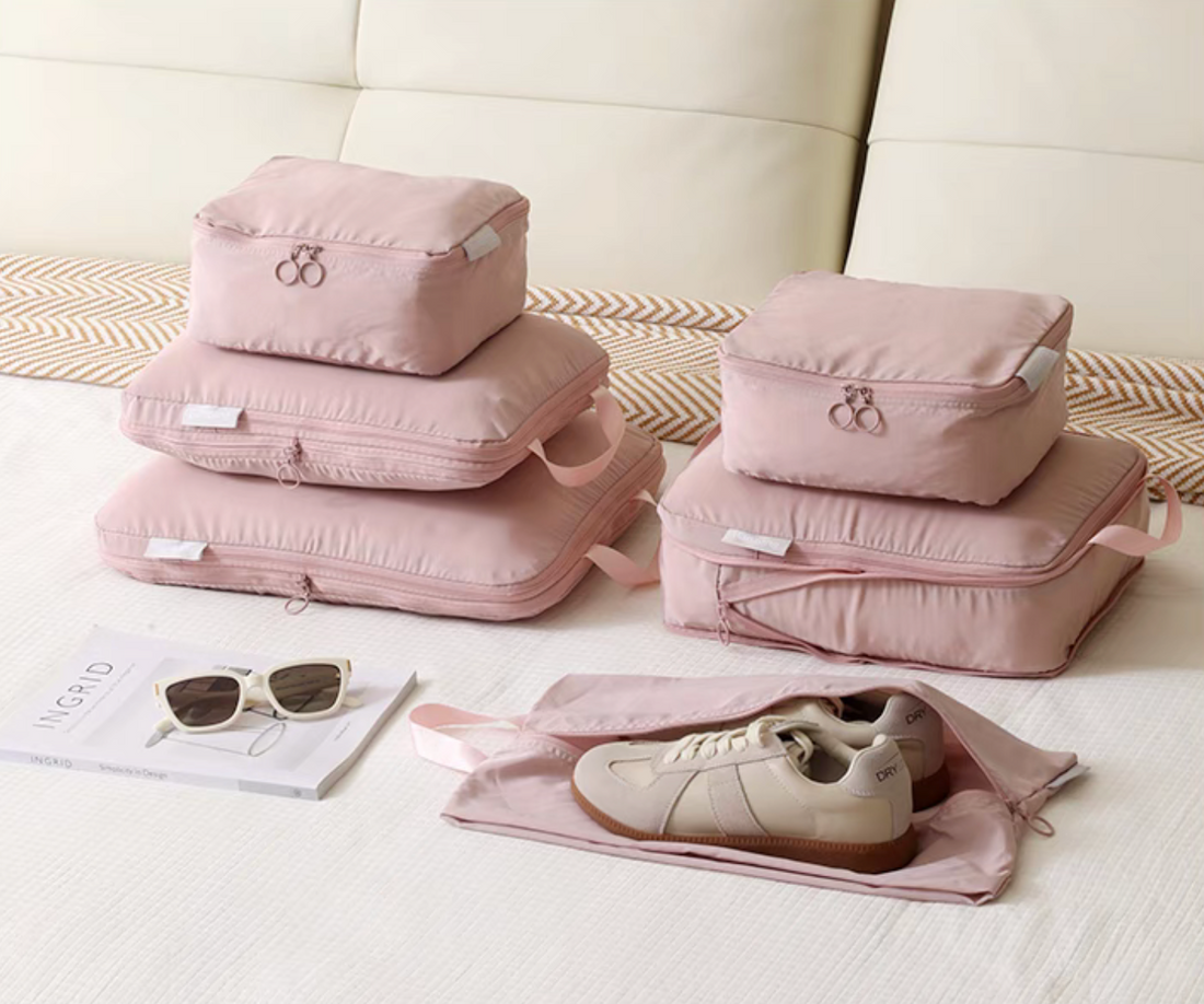 Bean Pink Compression Travel Packing Cubes with Shoe and Clothing Organizer Set arranged on bed with stacked cubes and open shoe bag