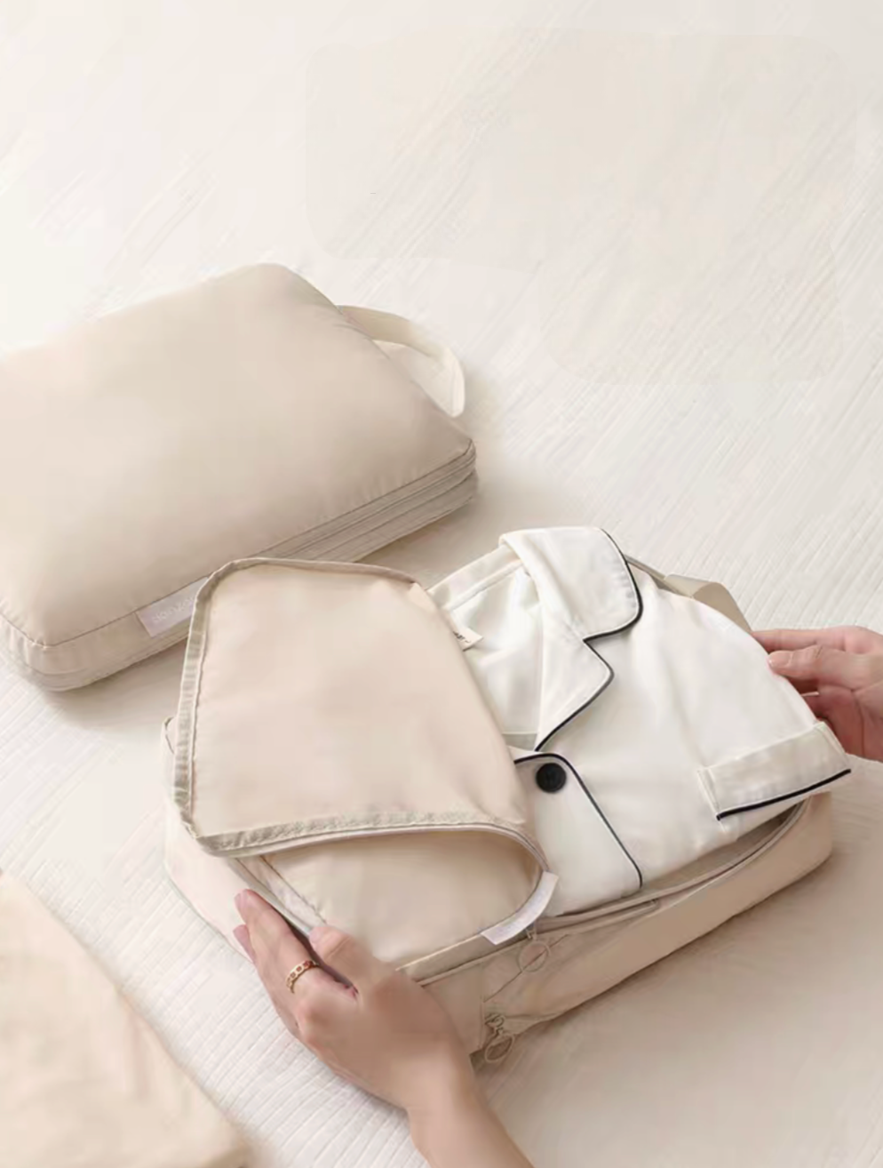Beige Compression Travel Packing Cubes with Shoe and Clothing Organizer Set with opened clothing cube holding folded pajama set