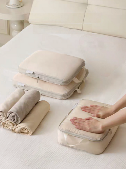 Beige Compression Travel Packing Cubes with Shoe and Clothing Organizer Set showing a clothing cube being pressed down to save packing space