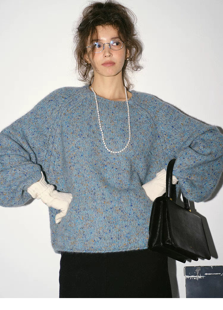 Crystal blue confetti knit sweater worn with hands on hips showcasing relaxed oversized fit and speckled yarn texture