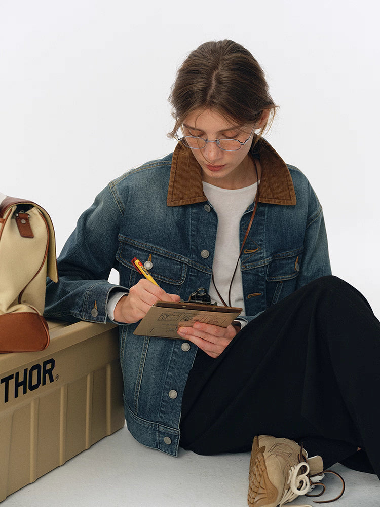 Lifestyle shot of model in contrast-collar denim jacket sitting and writing on clipboard next to canvas bag