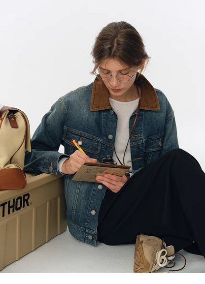 Lifestyle shot of model in contrast-collar denim jacket sitting and writing on clipboard next to canvas bag