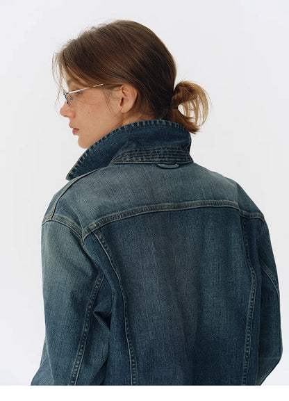 Back view of washed blue denim jacket with collar flipped up showing fading on the yoke