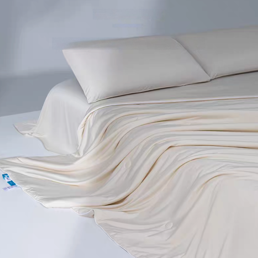 Beige cooling antibacterial summer quilt flowing across a bed showing lightweight breathable cooling comforter design.