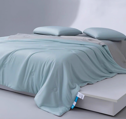 Blue and gray cooling summer comforter spread across a minimalist bed, highlighting lightweight breathable quilt design.