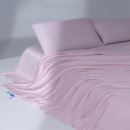 Lilac pink cooling antibacterial summer quilt layered over a bed showing lightweight breathable cooling fiber material.