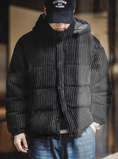 Man wearing Black corduroy down jacket front view styled with cap showing urban winter outfit look