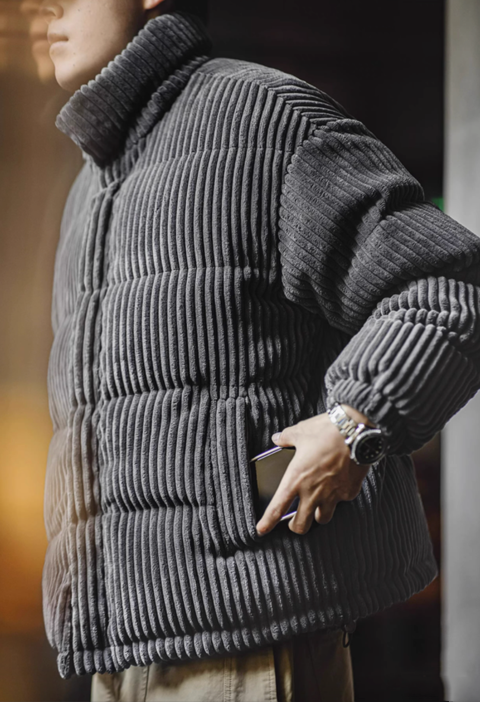 Close-up of Dark Gray corduroy down jacket showing plush ribbed texture and functional side pocket detail