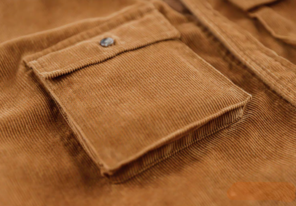 Close-up of Amber Corduroy Field Shirt chest pocket showing ribbed texture and button-flap detail