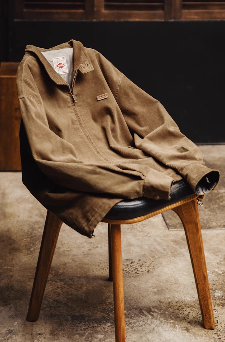 Corduroy Harrington jacket draped on a chair showcasing relaxed fit