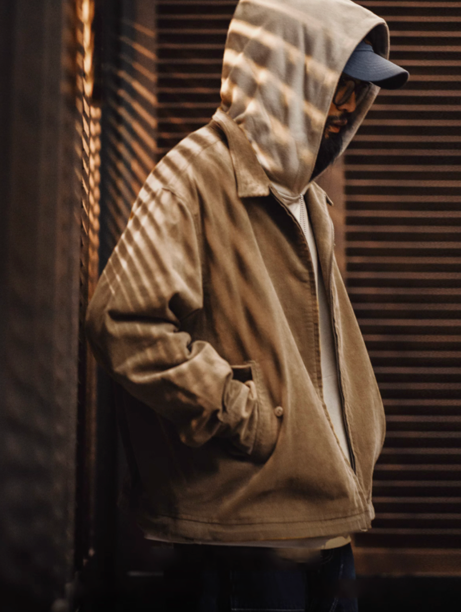 Model layering corduroy Harrington jacket over hoodie for streetwear look
