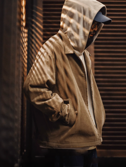 Model layering corduroy Harrington jacket over hoodie for streetwear look