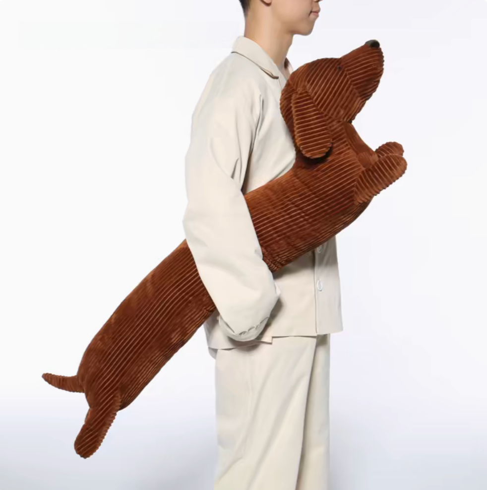 Person holding brown dachshund long body pillow demonstrating size and soft plush comfort