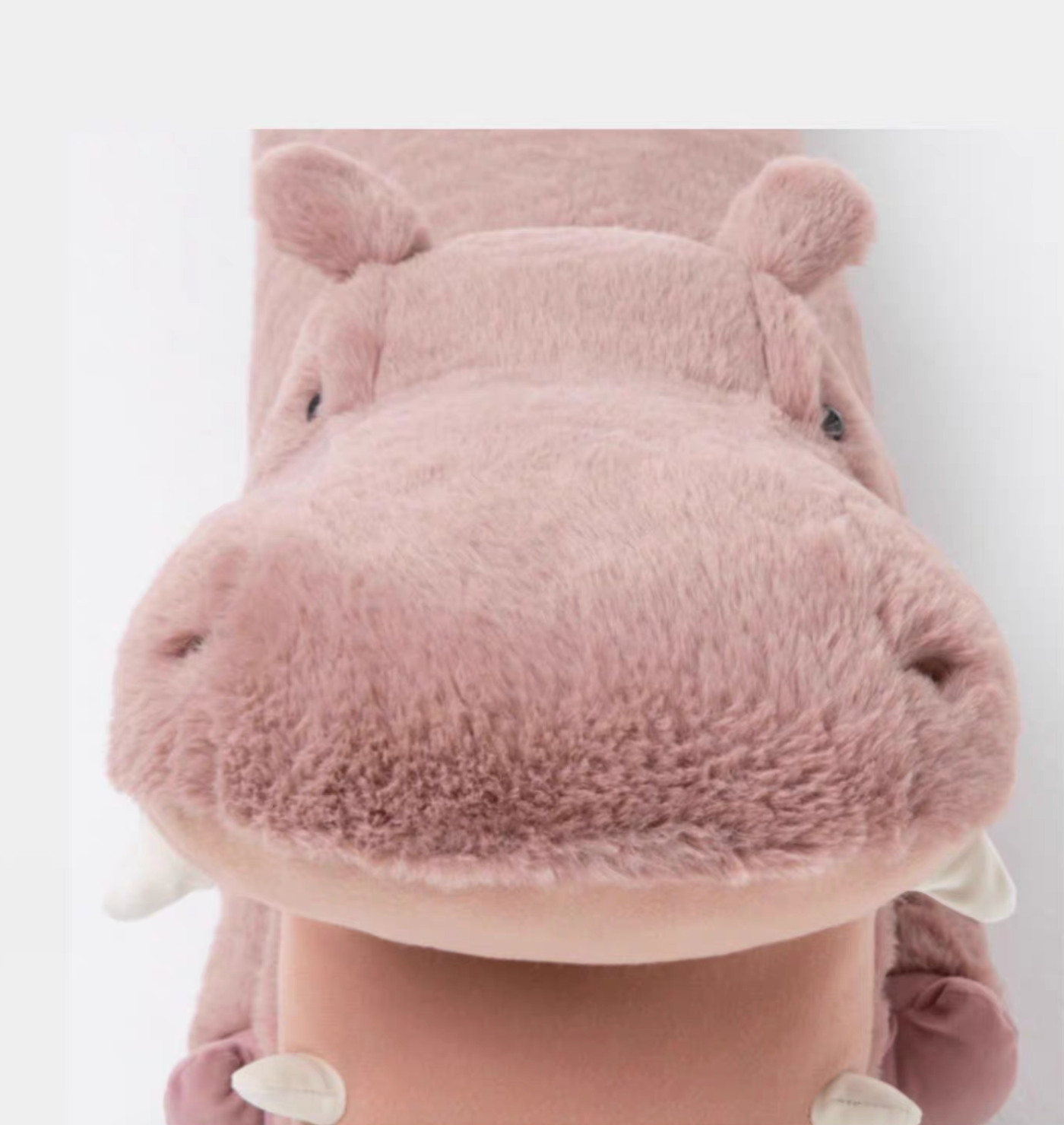 Close-up front view of pink hippo long body pillow showing soft plush face and rounded snout details