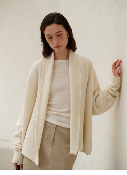 Model wearing Cozy Elegance Oversized Knit Cardigan in Ivory featuring open front design, shawl collar, and relaxed soft wool blend silhouette