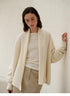 Model wearing Cozy Elegance Oversized Knit Cardigan in Ivory featuring open front design, shawl collar, and relaxed soft wool blend silhouette