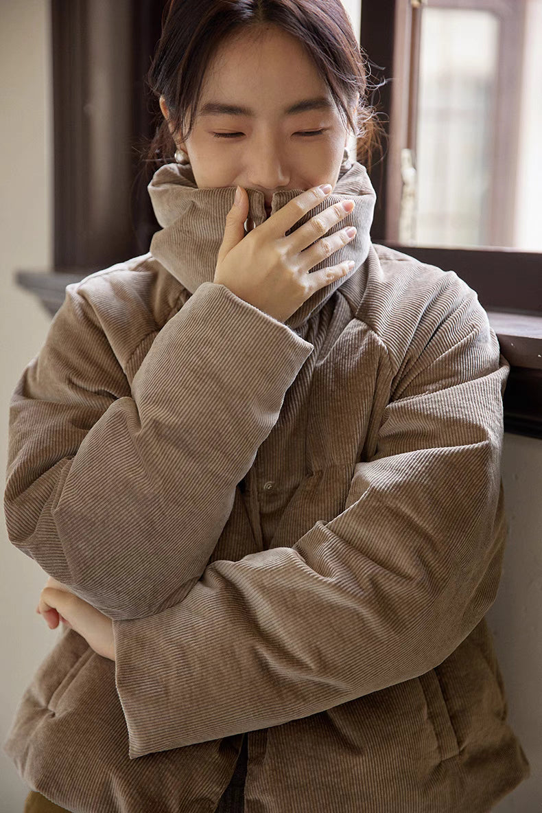Close-up of Cozy Quilted Corduroy Coat in light brown gray highlighting stand collar, quilted stitching, and soft corduroy fabric