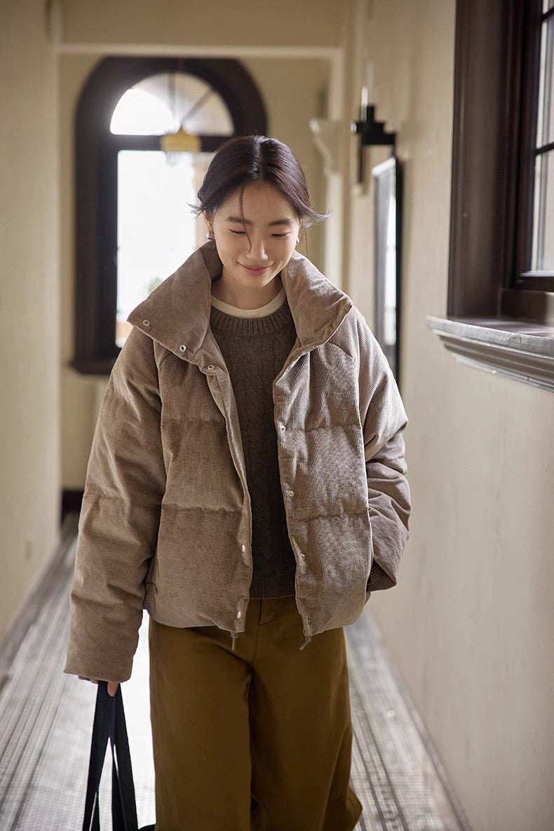 Model wearing Cozy Quilted Corduroy Coat in light brown gray walking indoors, featuring stand collar, quilted design, and relaxed oversized fit