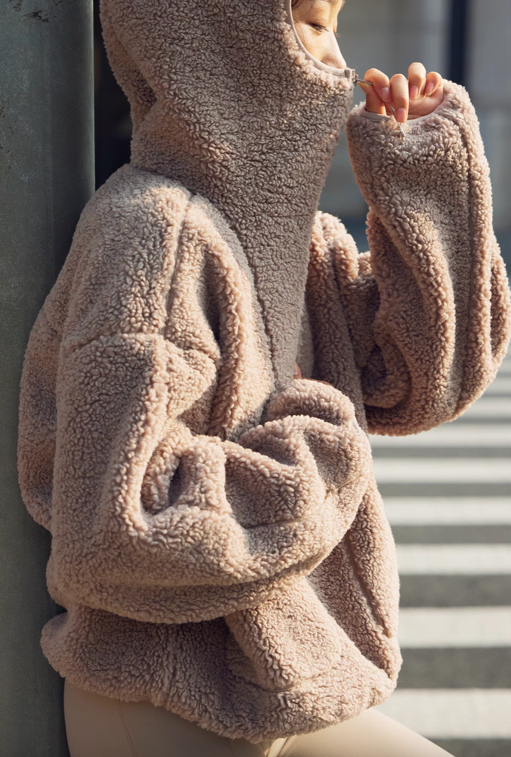 Side view of Cozy Sherpa Thermal Hoodie Pullover in brown showing high neckline zipped up, soft sherpa fabric, and relaxed sleeve design