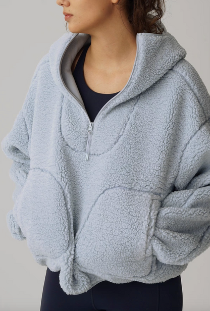 Angled front view of Cozy Sherpa Thermal Hoodie Pullover in light blue highlighting half-zip neckline, hood shape, and plush fleece texture