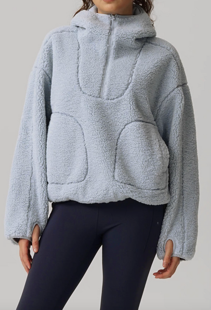 Front studio view of Cozy Sherpa Thermal Hoodie Pullover in light blue featuring half-zip closure, kangaroo pockets, and relaxed cropped fit