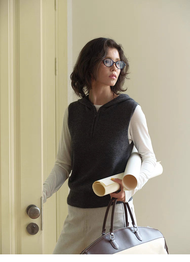 Dark gray Cozy Sleeveless Pullover Sweater styled with tote bag and layered outfit, showcasing relaxed fit and hooded design