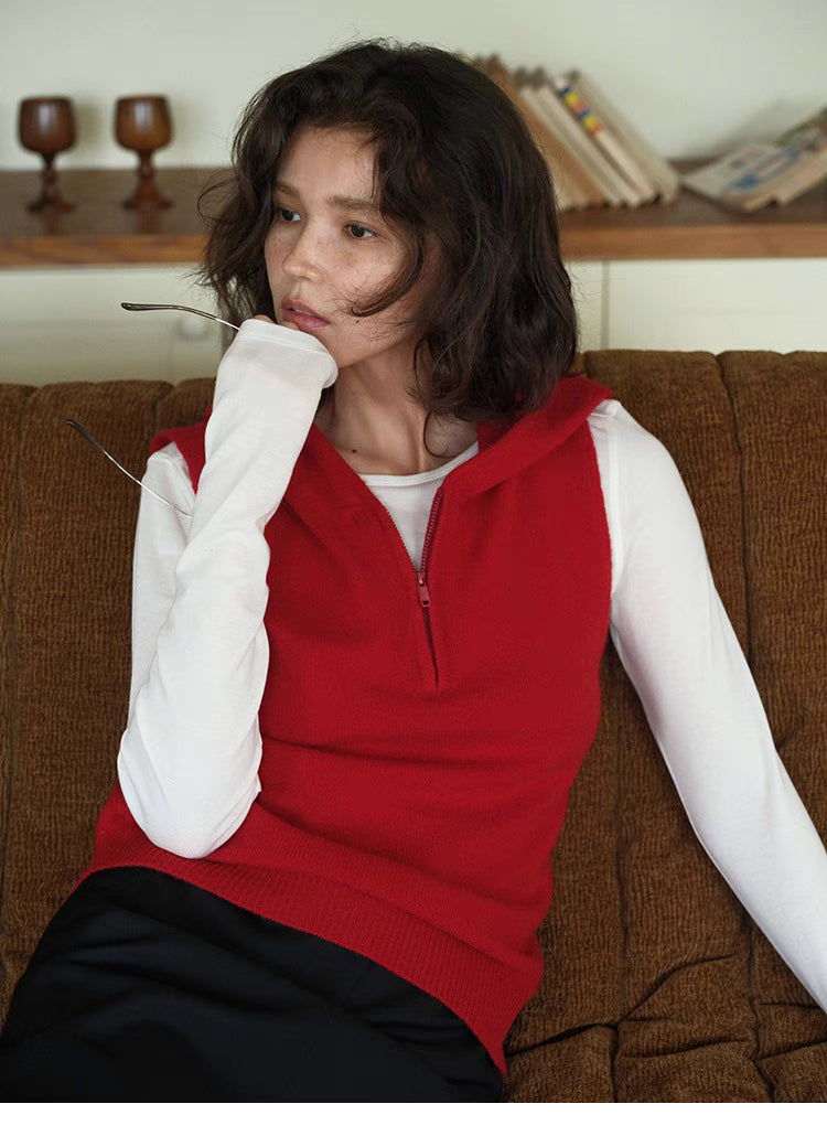 Cozy Sleeveless Pullover Sweater in red, close-up lifestyle view with hooded design and half-zip front, layered over long sleeve top