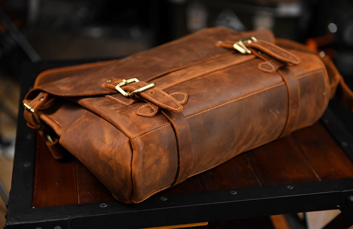 Bottom view showing structure and double-strap stitching of leather satchel.