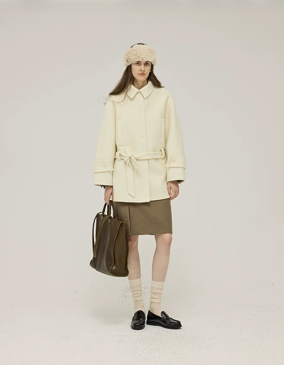 Front view of a Cream belted wool coat with point collar and single-breasted buttons