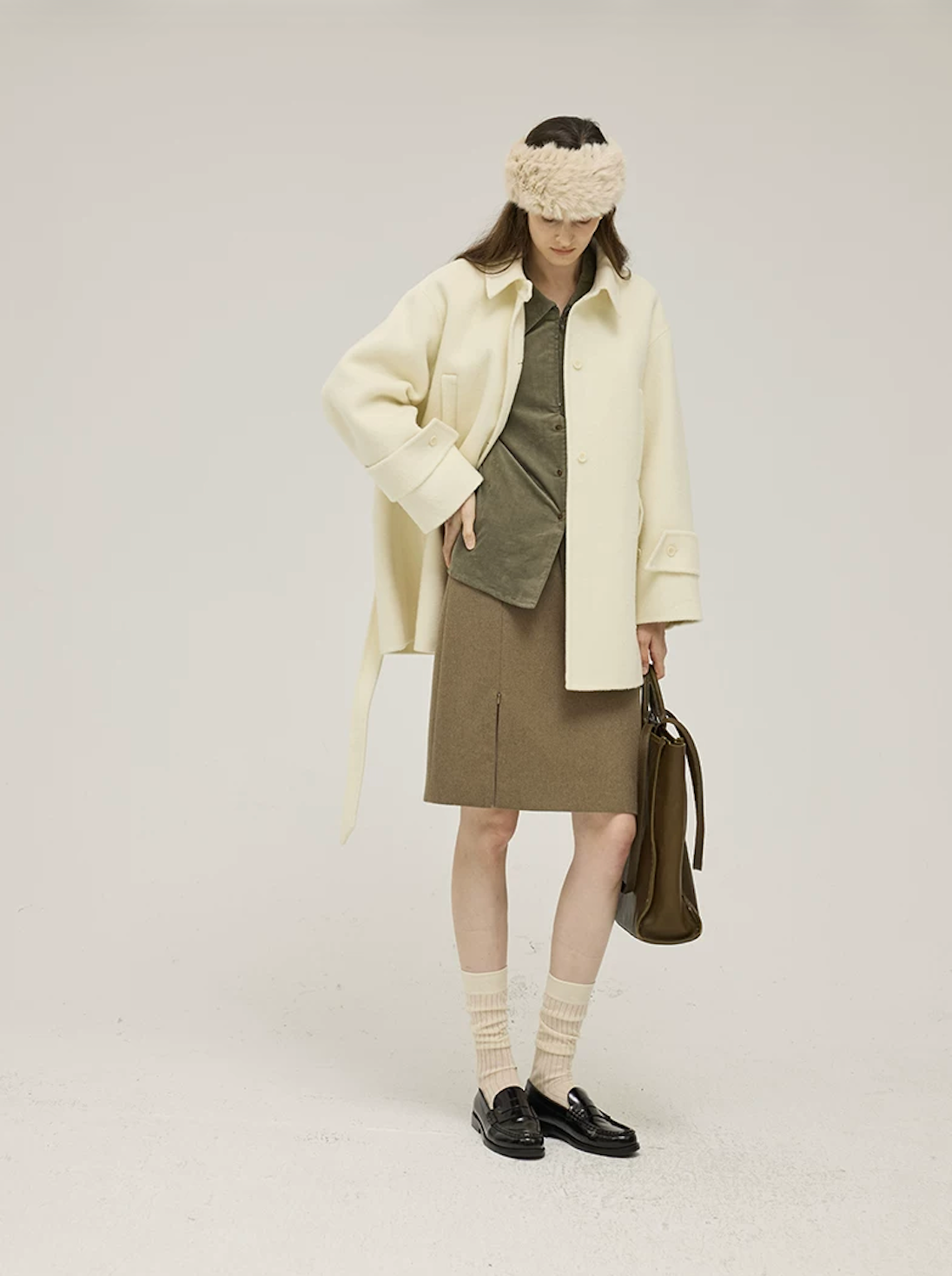 Cream short wool coat worn open with the belt hanging loose and wide cuffs
