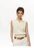 Waist-up view of Cream cotton knit polo top showing V-neck collar and deep ribbed hem