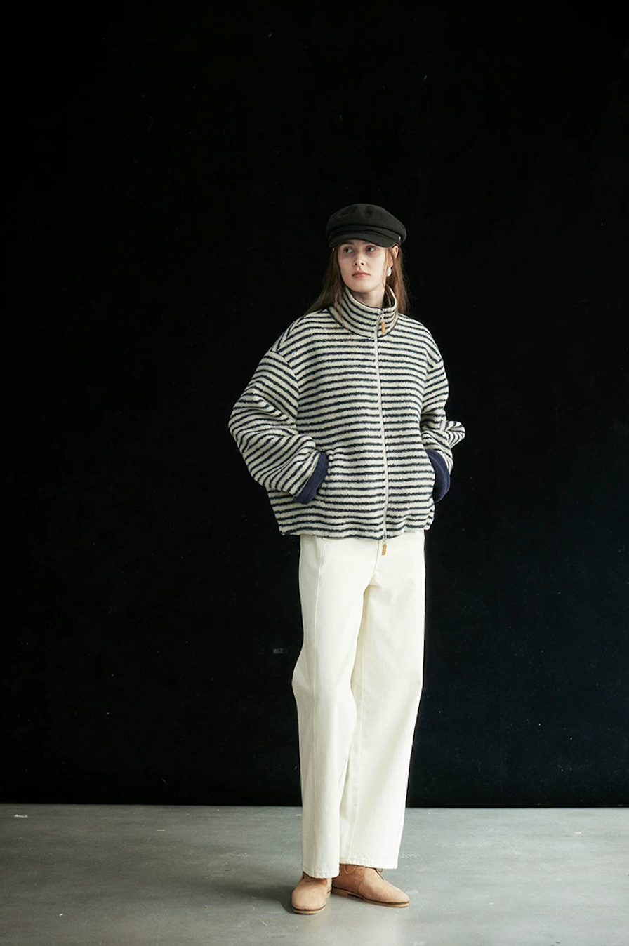 Full-length view of a Cream/Navy Stripe cropped zip jacket with hands in the slanted pockets
