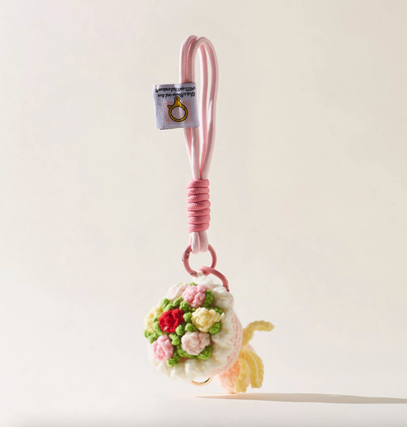 Pink crochet flower bouquet bag charm with roses and paracord loop.
