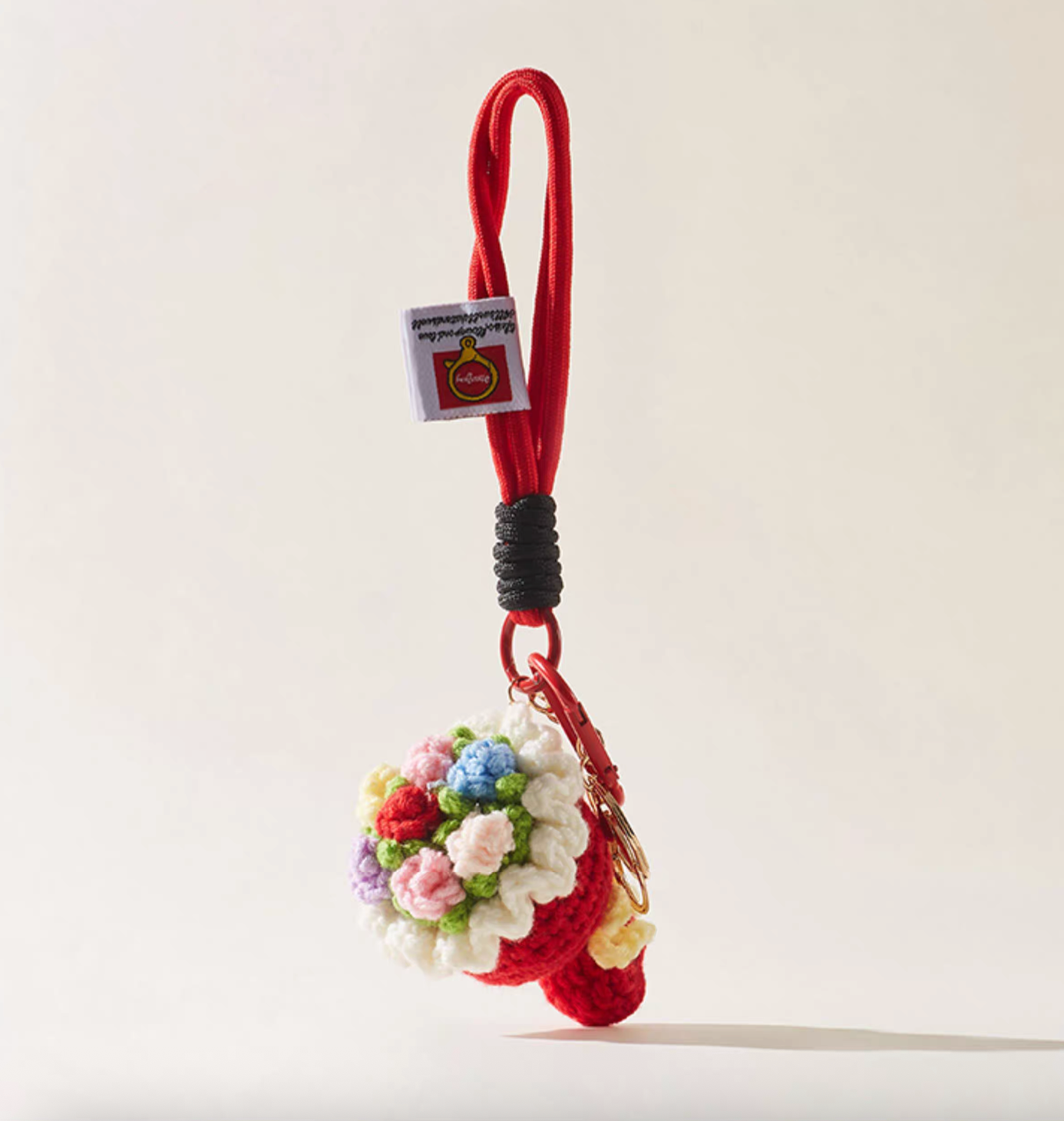 Handmade crochet flower bouquet keychain with red rope loop and roses.
