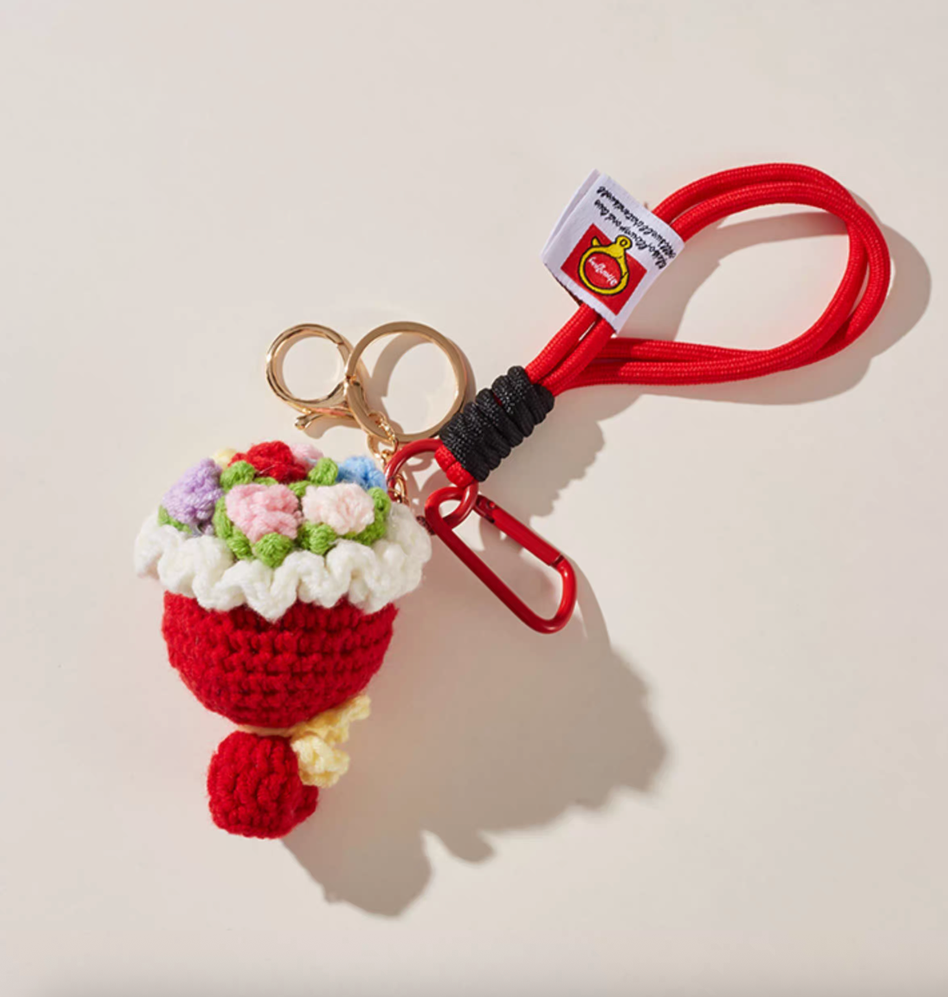 Handmade red crochet flower bouquet keychain with rope loop, gold keyring and red mini carabiner, displayed on a neutral background.
