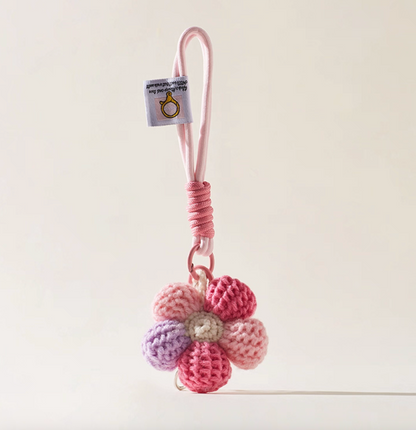Pink crochet daisy bag charm keychain with rope loop.