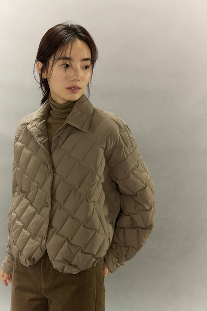 Close front view of khaki brown cropped quilted goose down shirt jacket with diamond quilting and shirt collar.