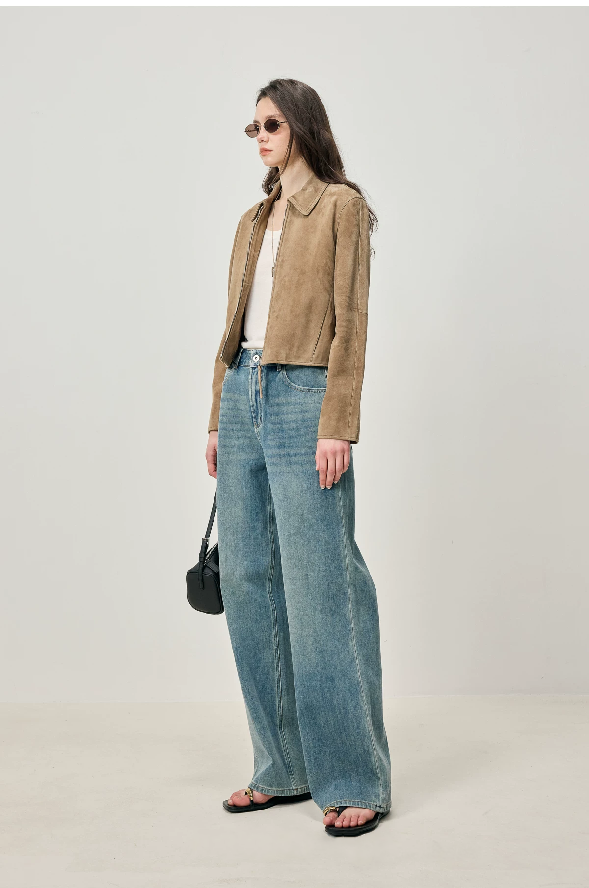 Side view of cropped fawn suede jacket showing paneled sleeves and waist-length hem