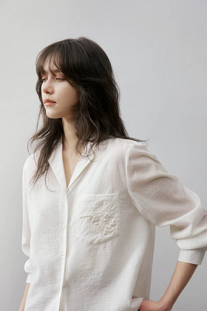 Close-up of ivory Cuban collar shirt collar and embroidery detail