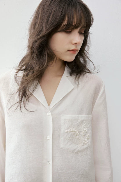 Close-up of ivory Cuban collar shirt notched collar and pocket