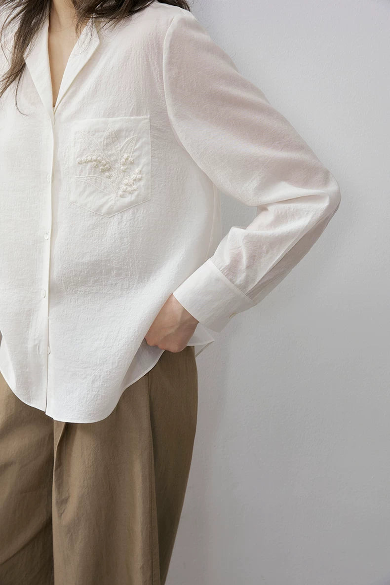 Close-up of ivory Cuban collar shirt embroidered chest pocket detail