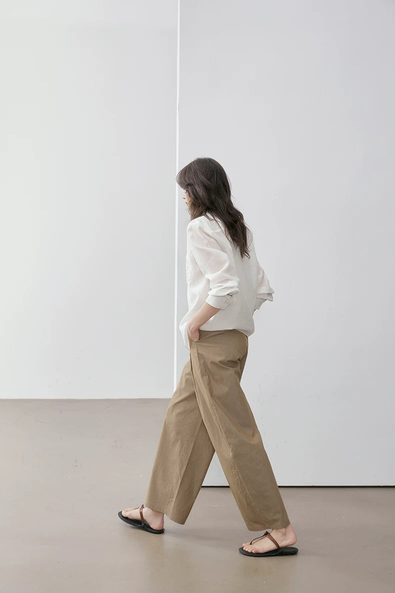Side view of woman walking in ivory Cuban collar shirt