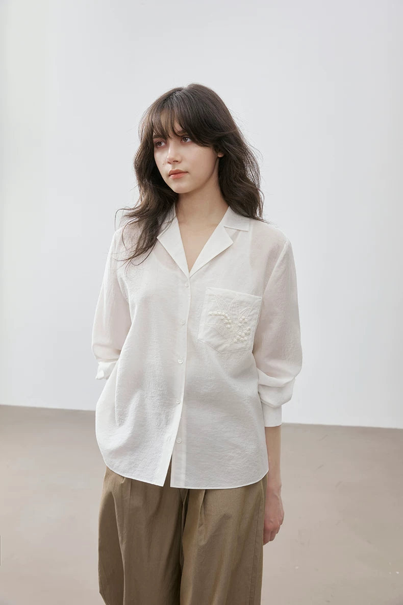 Front view of ivory Cuban collar shirt with embroidered pocket, standing pose