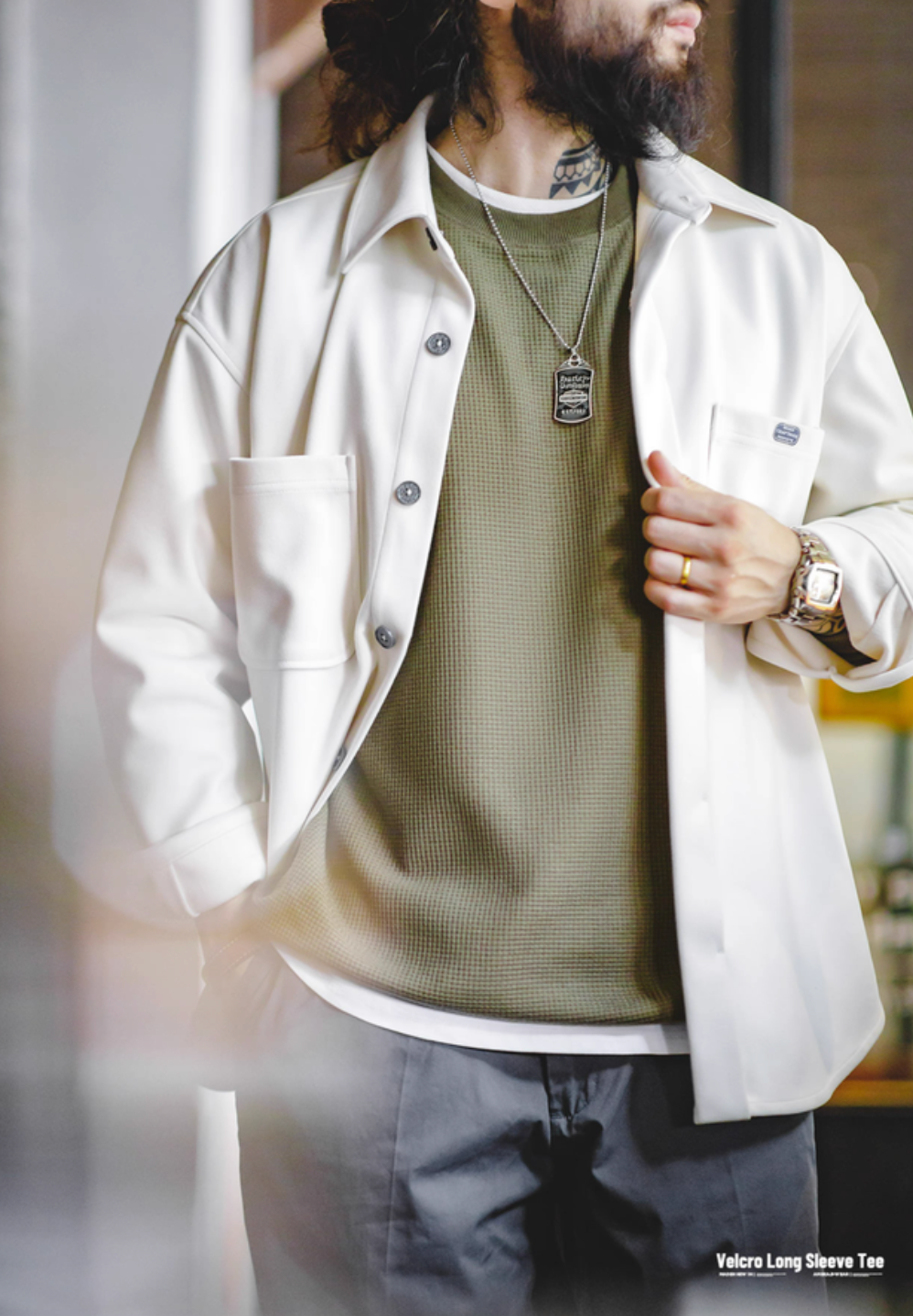 Man styling army green custom Velcro long sleeve waffle tee layered under white shirt for casual outfit