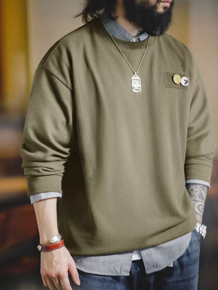 Man wearing army green custom Velcro long sleeve waffle tee showing chest velcro patch with decorative pins