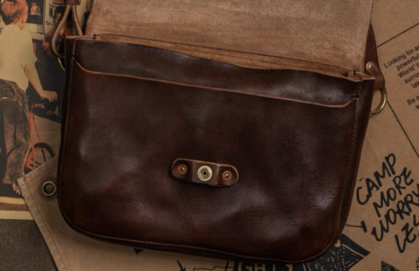 Italian leather crossbody with flap open showing inner suede lining and magnetic snap closure