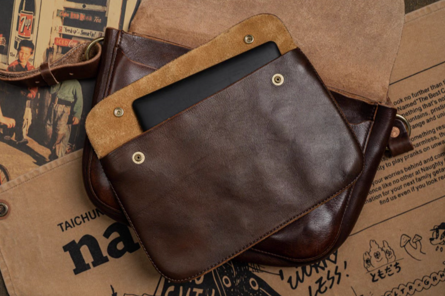 Brown full-grain leather crossbody showing tablet stored inside suede-lined compartment