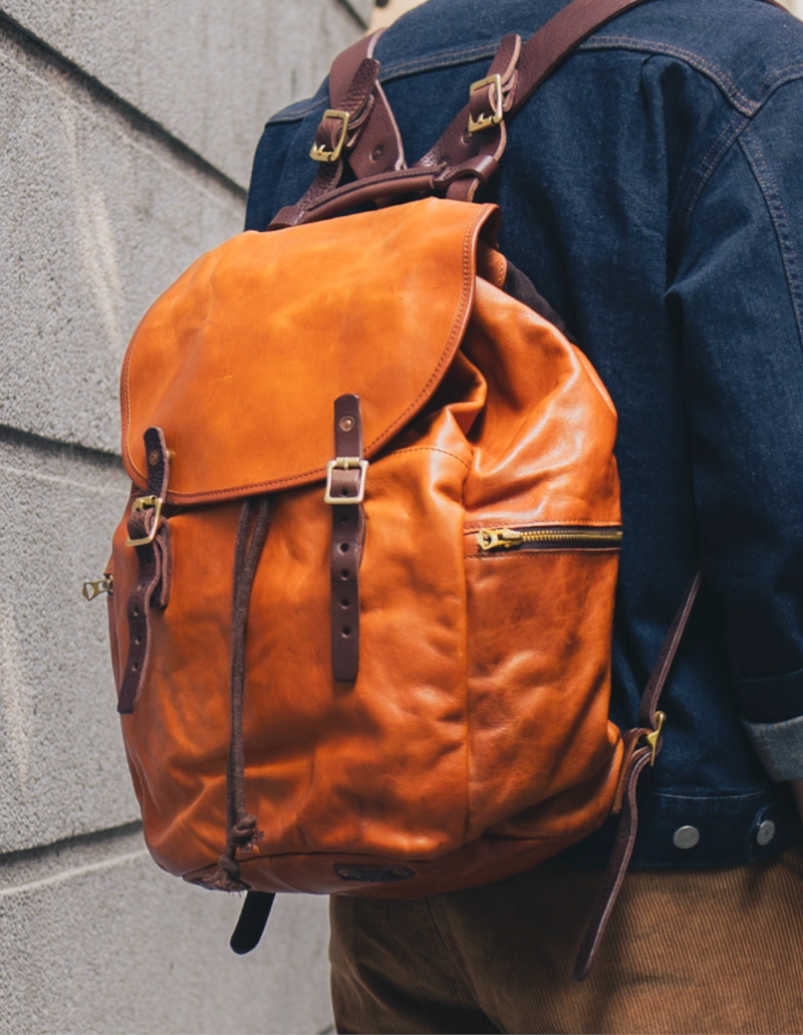 WWII paratrooper-inspired leather rucksack in caramel brown with canvas back panel